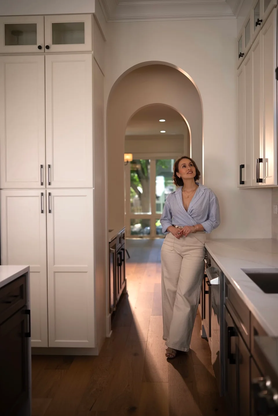Professional portrait framed by a kitchen and arched doorway