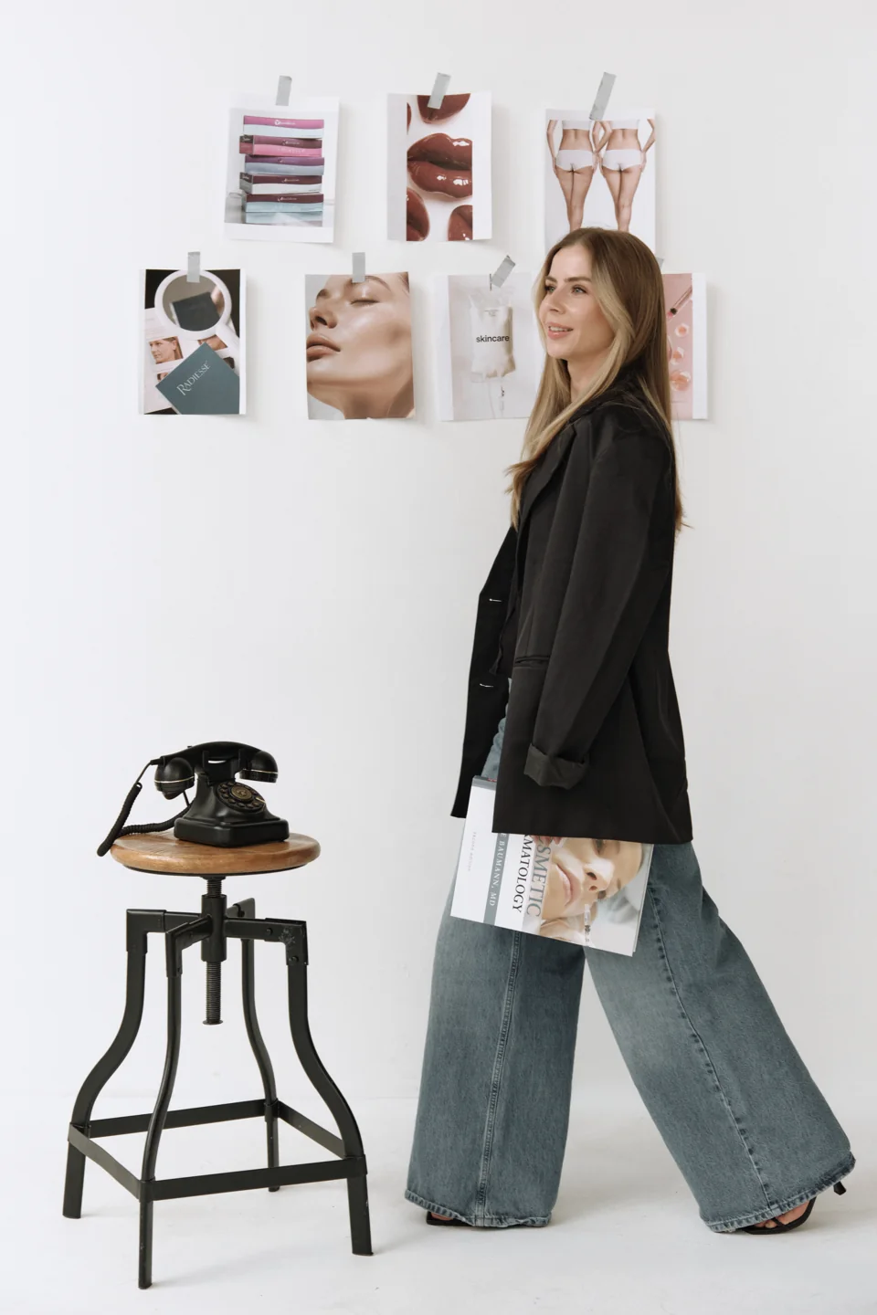 Creative studio portrait beside a moodboard and vintage telephone