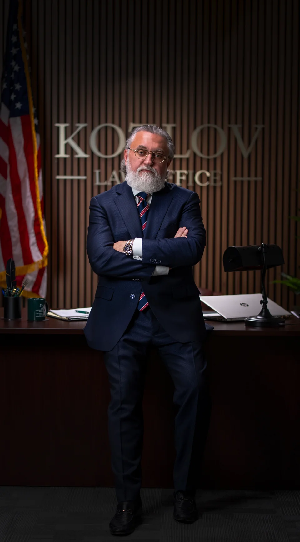 Full-length executive portrait in a wood-paneled office