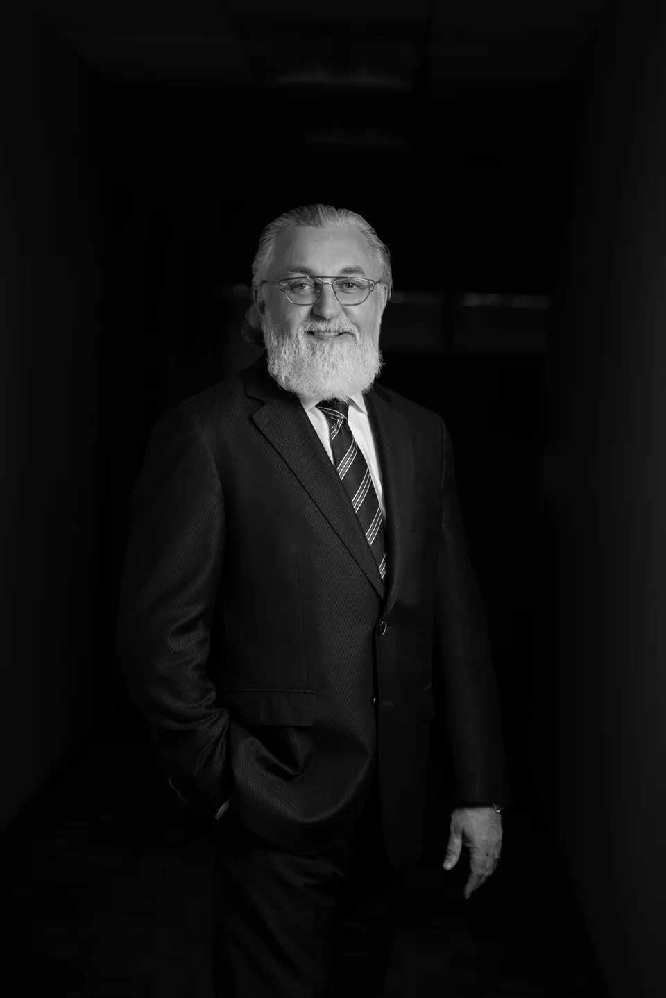 Black-and-white standing portrait of an executive in a suit