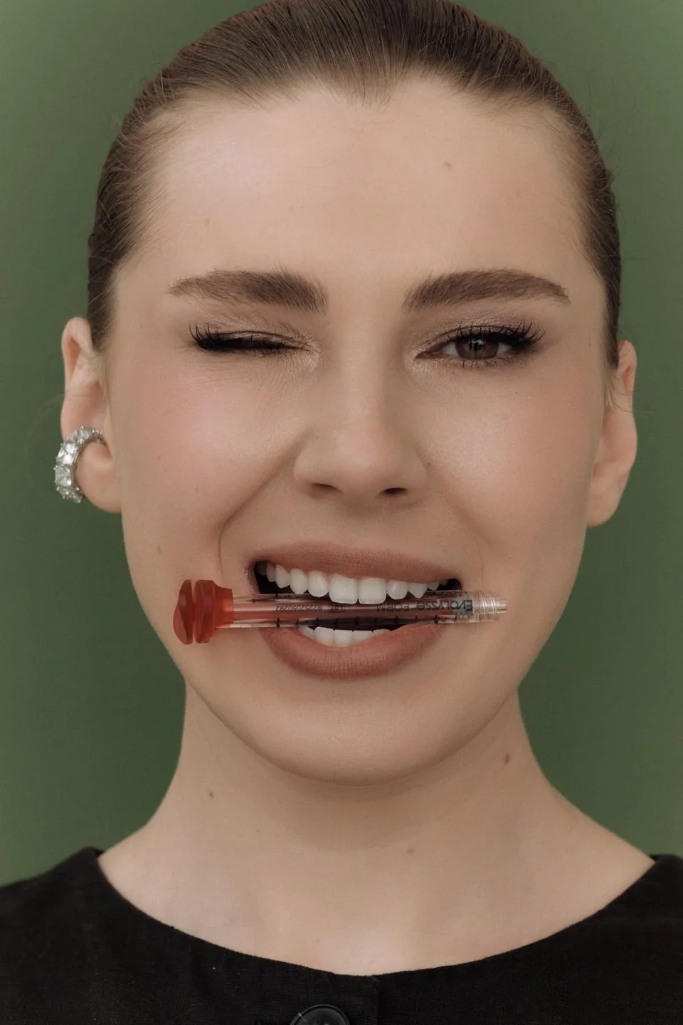 Beauty portrait with lip brushes against a green background