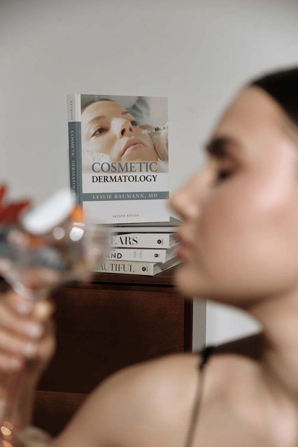 Editorial detail with books and a softly focused woman in the foreground