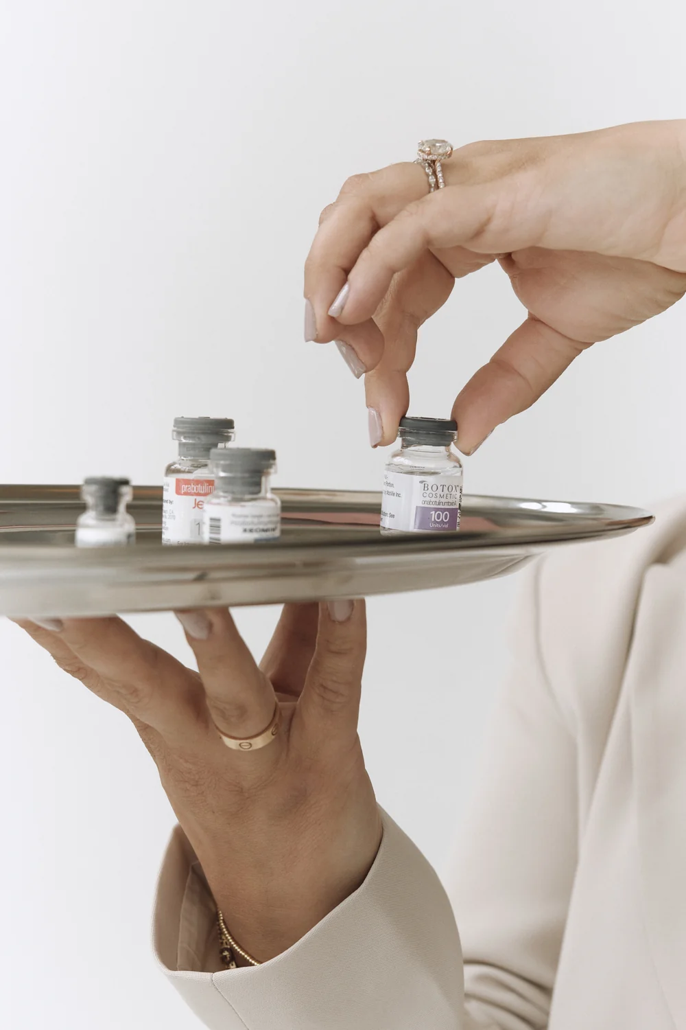 Close-up of hands arranging small vials on a tray